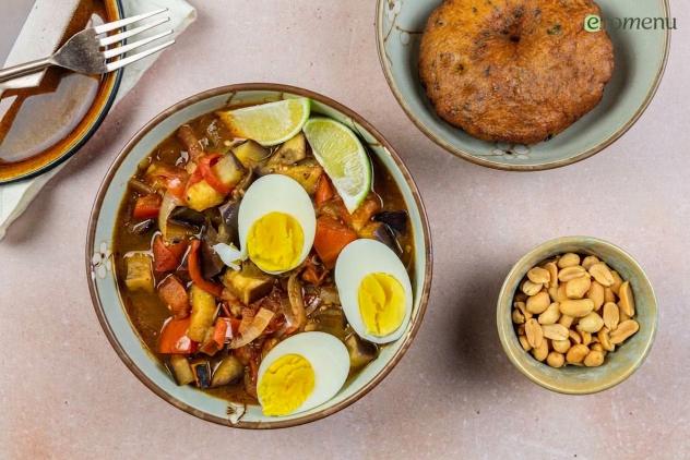 Kruidige aubergine stoof met een bara, eitje en pinda's